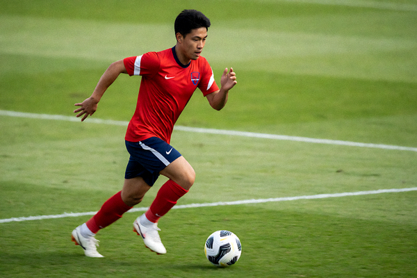 足球运动员在比赛中加速冲刺带球的画面